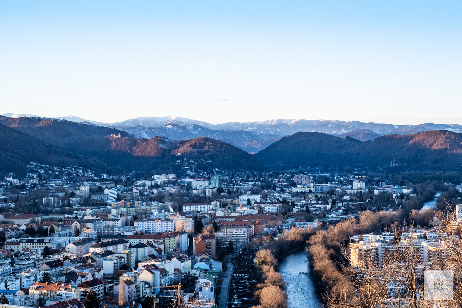 Blick übers winterliche Graz in Richtung schneebedeckte Berge