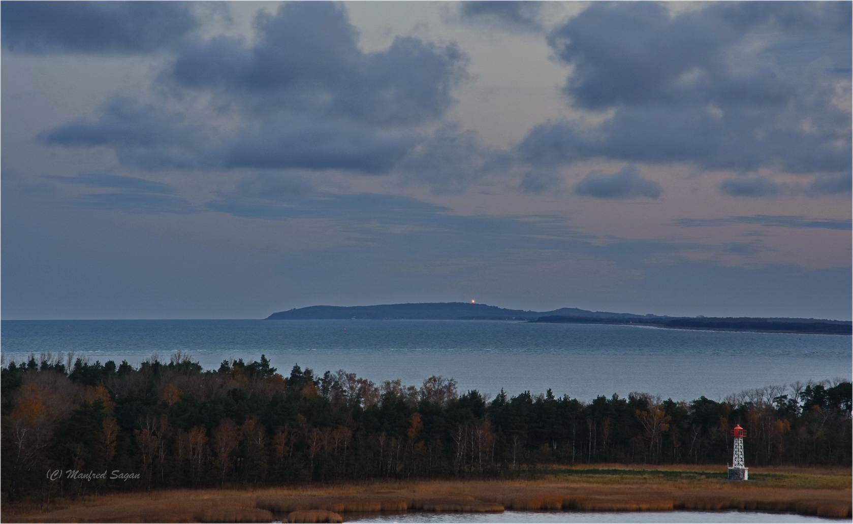 Blick vom Festland über den Bock zur Insel Hiddensee, deren Leuchtfeuer zu erkennen ist.