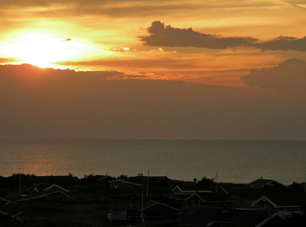Blick von der "Roten Bank" auf den Ferienort Harrerenden und das Meer beim Sonnenuntergang.