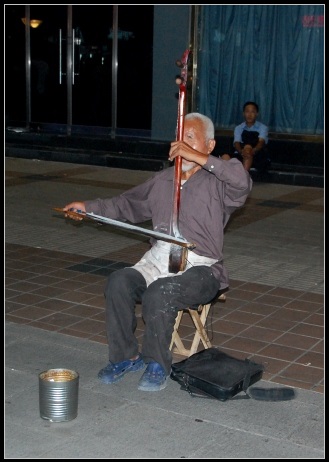 Blinder Straßenmusiker in der Fußgängerzone