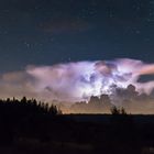 Blitz in Gewitterwolke unter'm Sternenhimmel