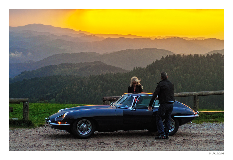 Blue E-Type in front of a red sky