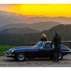 Blue E-Type in front of a red sky