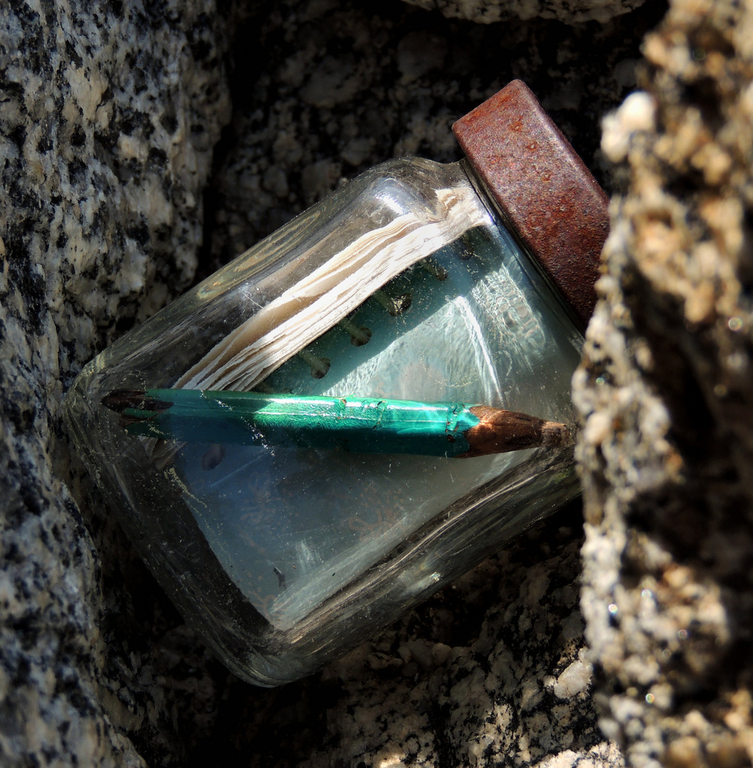 blue pencil in glass jar register on mountain peak