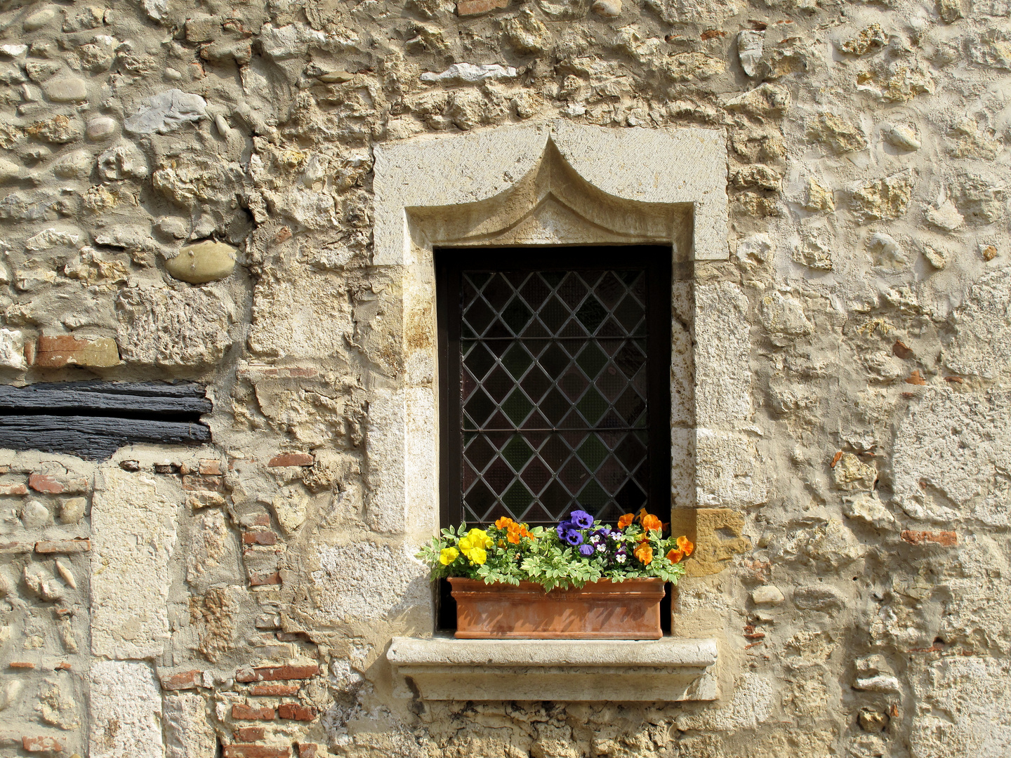 Blumenfenster in einer Gasse in Perouges