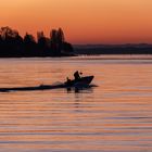 Boat silhouette at sunrise on lake Bodensee, Germany