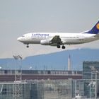 Boeing 737-300 im Landeanflug auf Frankfurt am Main - im Hintergrund einer der Terminals