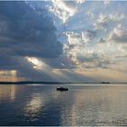 Boot als Silhouette auf dem Steinhuder Meer mit Sonnenstrahl und dramatischem Wolkenhimmel