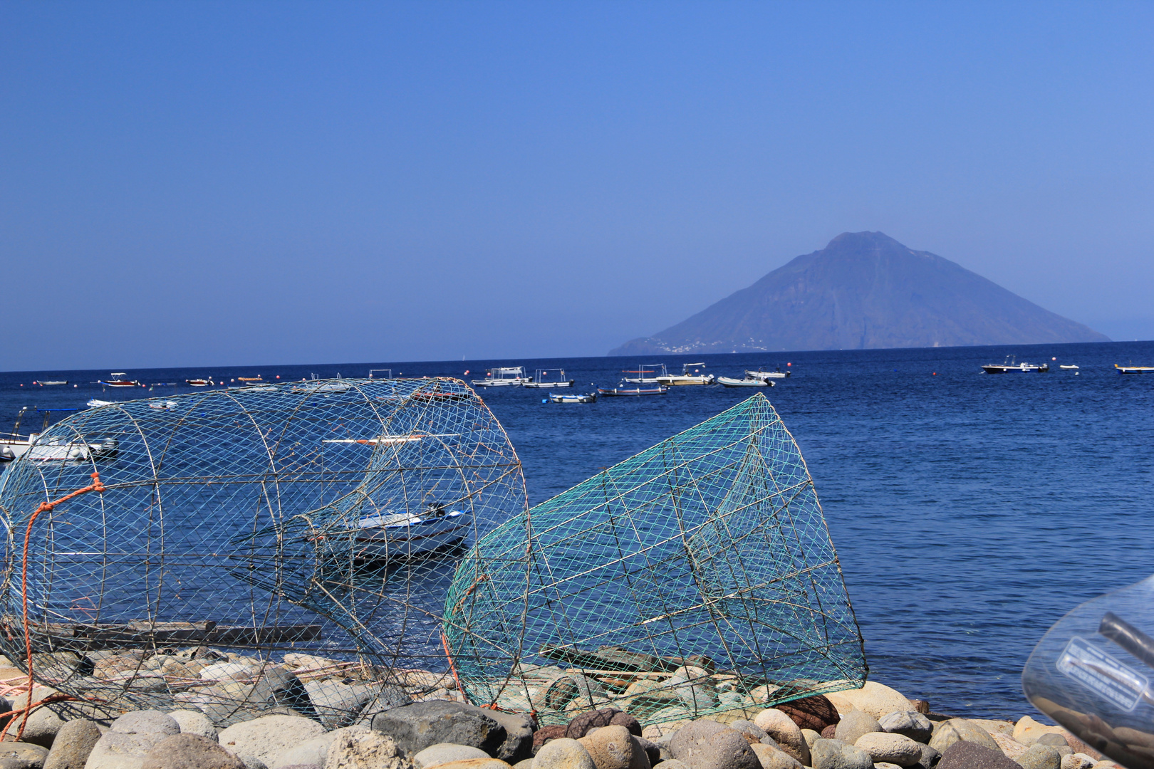 Boot im Netz auf Panarea, im Hintergrund die Insel Stromboli, Juni 2014