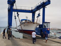 Boot wird durch Kran ins Wasser befördert