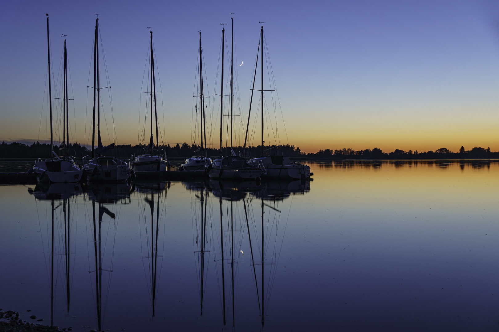 Boote in der blauen Stunde mit Sichelmond