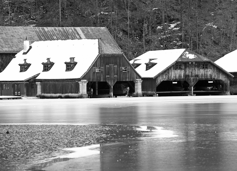 Bootshäuser am Königssee mit Eisschicht