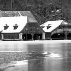 Bootshäuser am Königssee mit Eisschicht