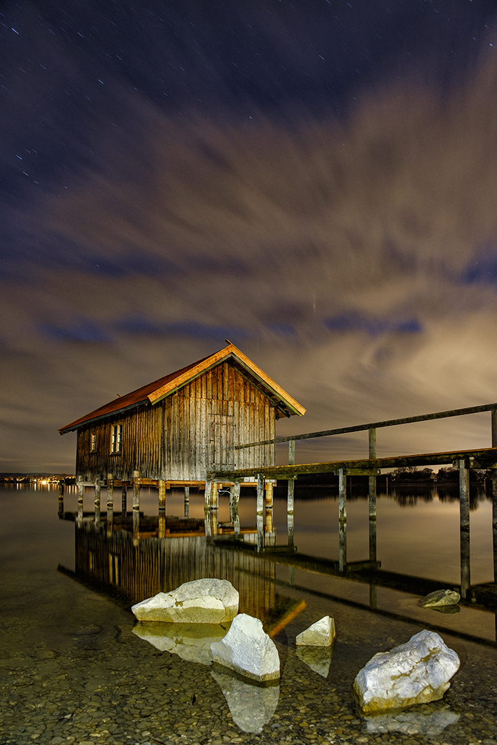 Bootshaus in Stegen am Ammersee, Nachtaufnahme mit Wasserspiegelung