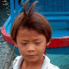 Boy arranges the wharfs for the fishing boats