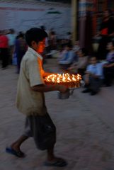 Boy brings new lighted butter lamps to the Gompa