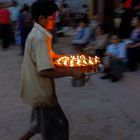 Boy brings new lighted butter lamps to the Gompa