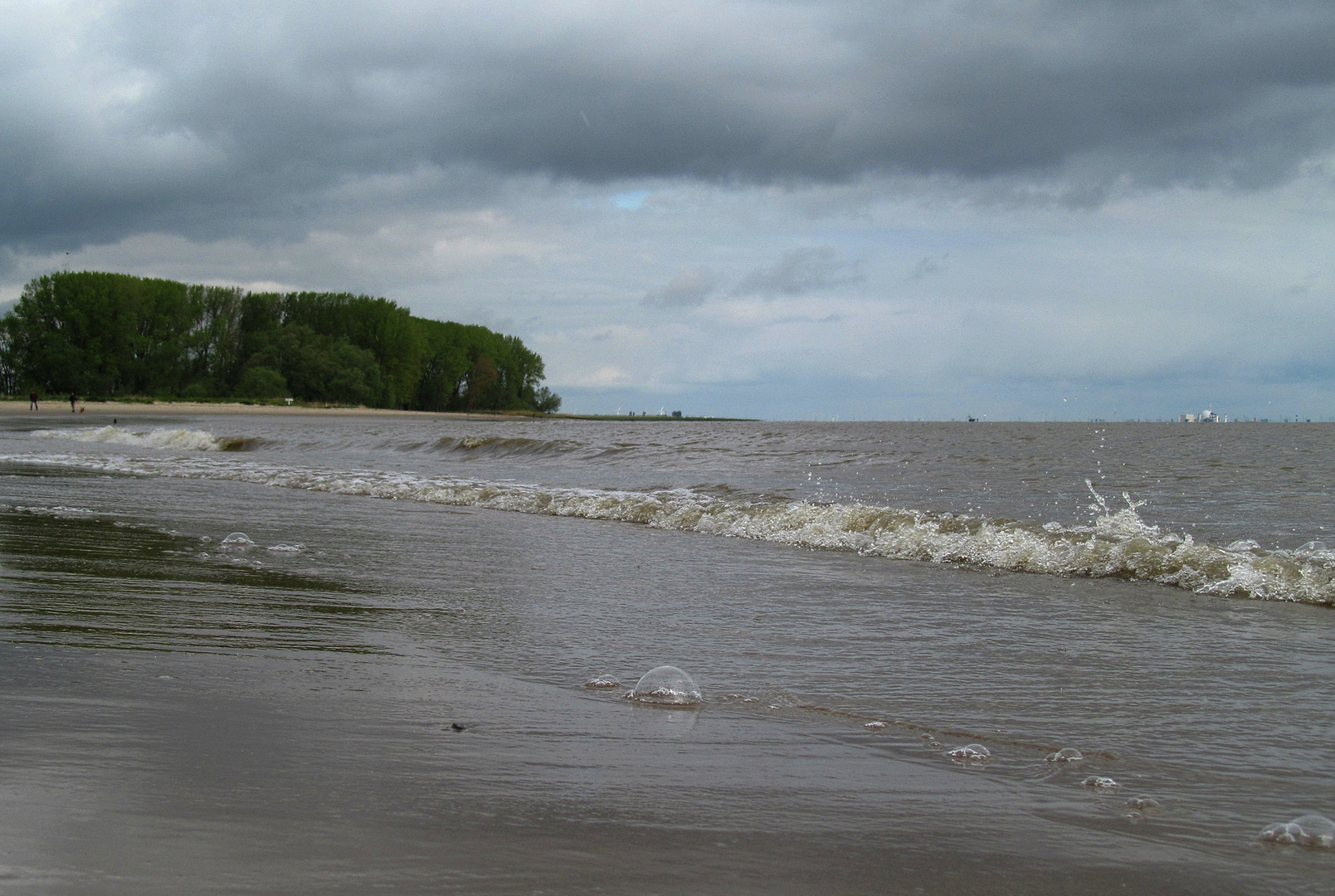 Brandung mit Blasenbildung an der Elbe bei auflaufendem Wasser ... 