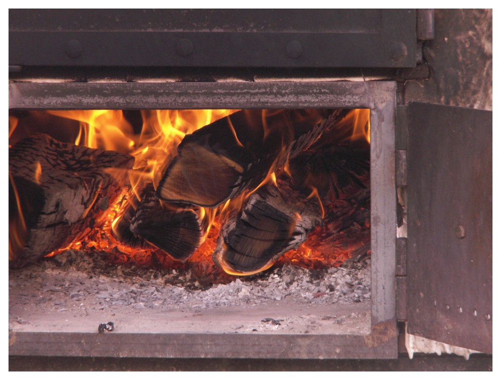 Brennendes Holz in einem alten Backofen