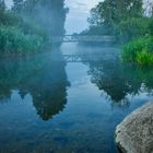 Bridge over foggy water