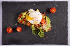 Brot, Avocado, Paradeiser und pochiertes Ei