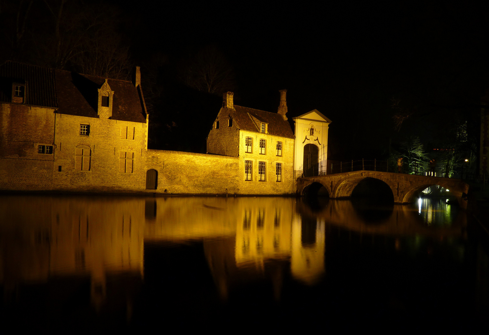 Brücke und Eingangstor zum Beginenhof in Brügge bei Nacht