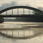 Brückenspiegelung mit leichtem Dampf über dem Wasser