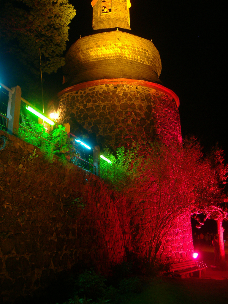 Bunt angeleuchteter kleiner Turm im Dunklen