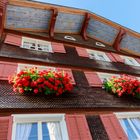 Bunte Holzfassade mit Blumenschmuck