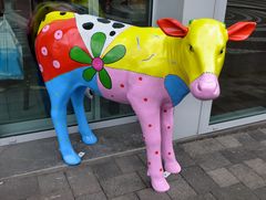 Bunte Kuh als Blickfang vor einem Restaurant