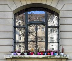 Bunte Töpfe vor spiegelndem Fenster