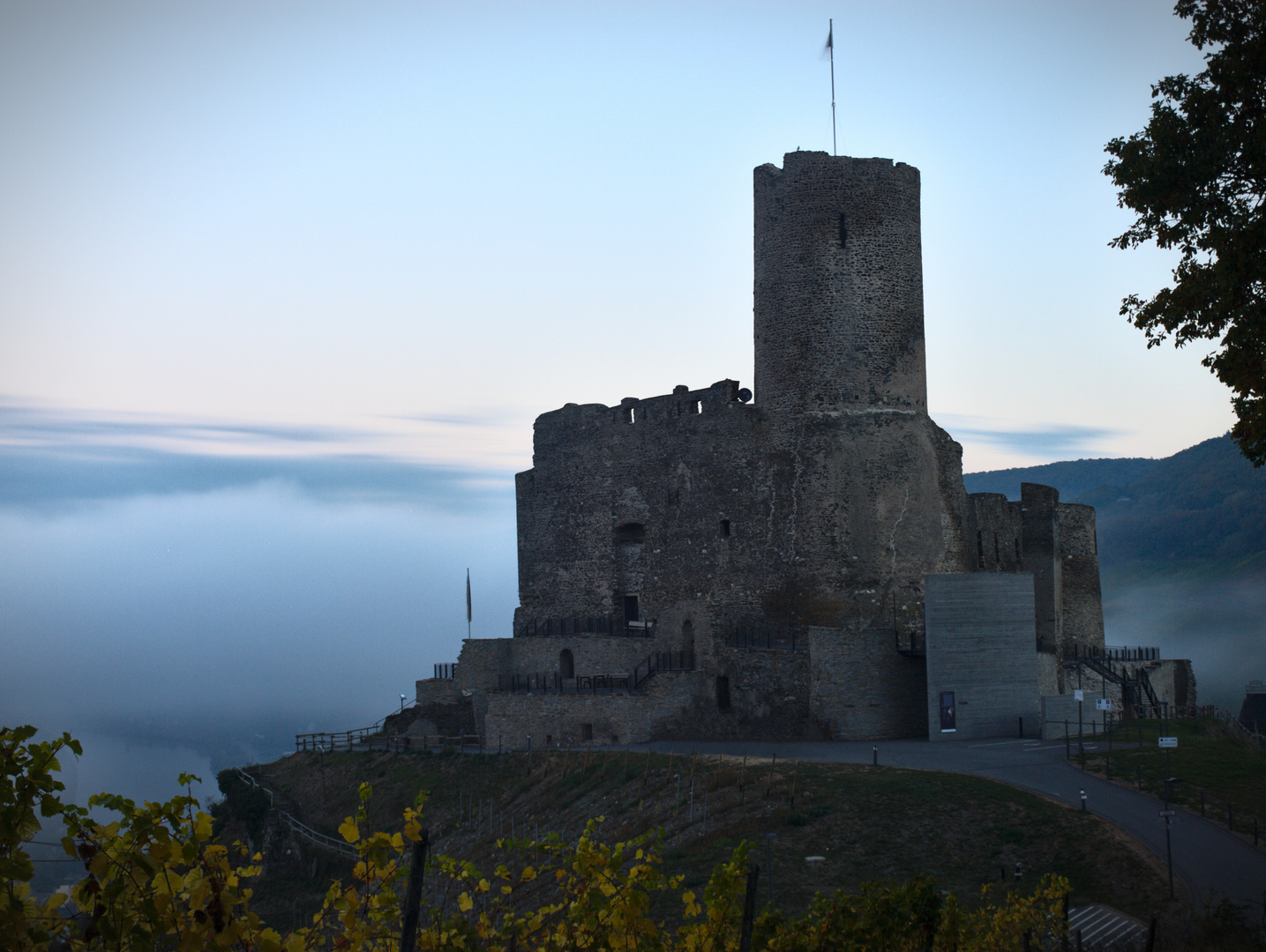 Burg mit Nebel im Hintergrund bei Sonnenaufgang