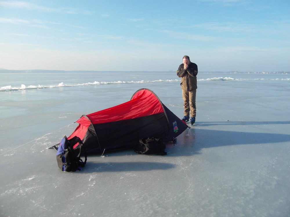 Camping auf dem Eis, zugefrorener Müggel See mit Zelt und Mensch