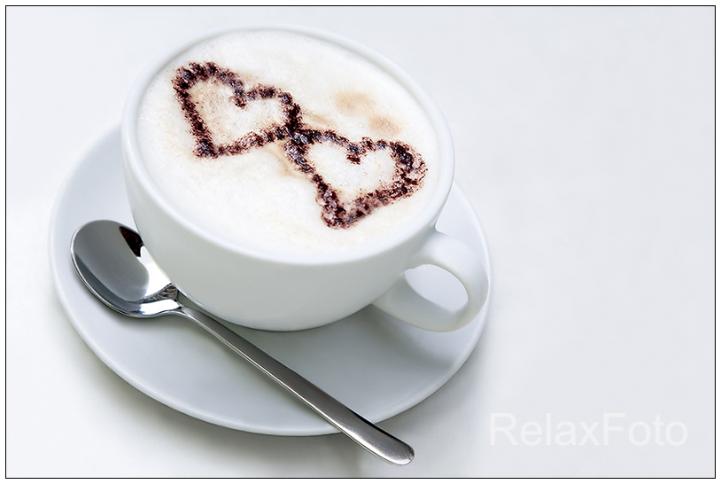 "Capuccino in love" - Weiße Tasse Capuccino mit zwei Herzen aus Kakaopulver