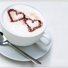 "Capuccino in love" - Weiße Tasse Capuccino mit zwei Herzen aus Kakaopulver