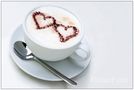 "Capuccino in love" - Weiße Tasse Capuccino mit zwei Herzen aus Kakaopulver von RelaxFoto.de