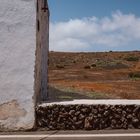 Casa con muro y paisaje.