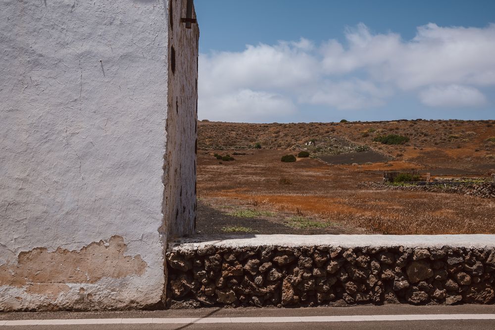 Casa con muro y paisaje.