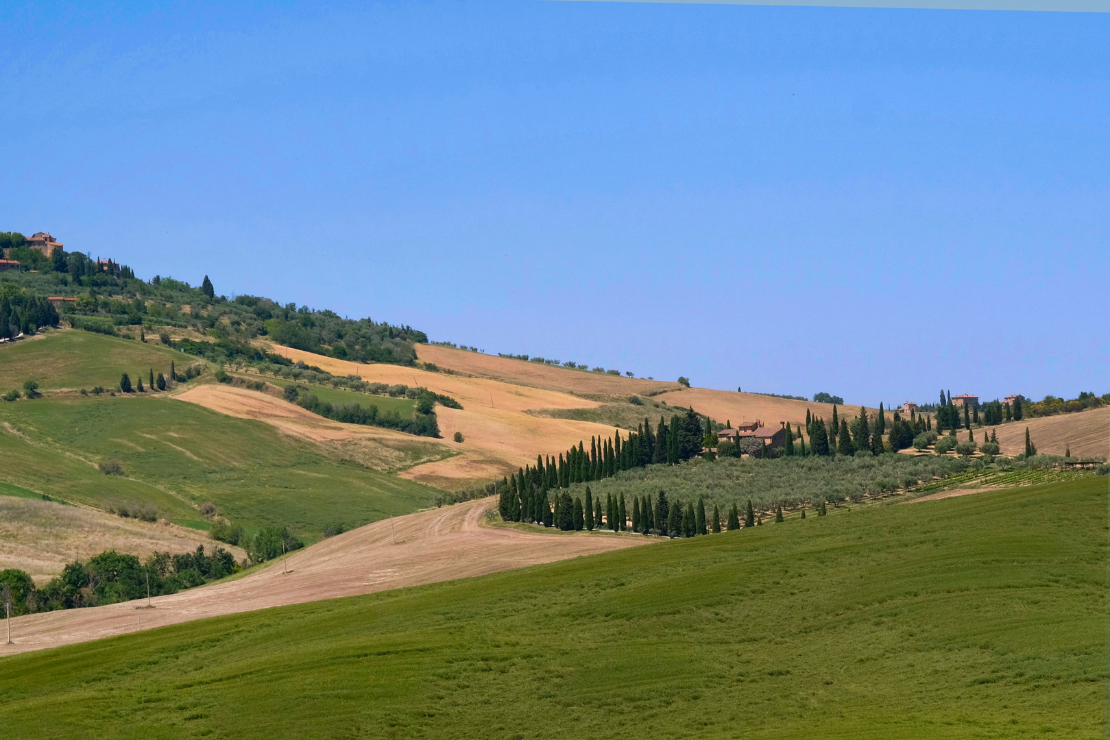 Casali, cipressi e campi arati.