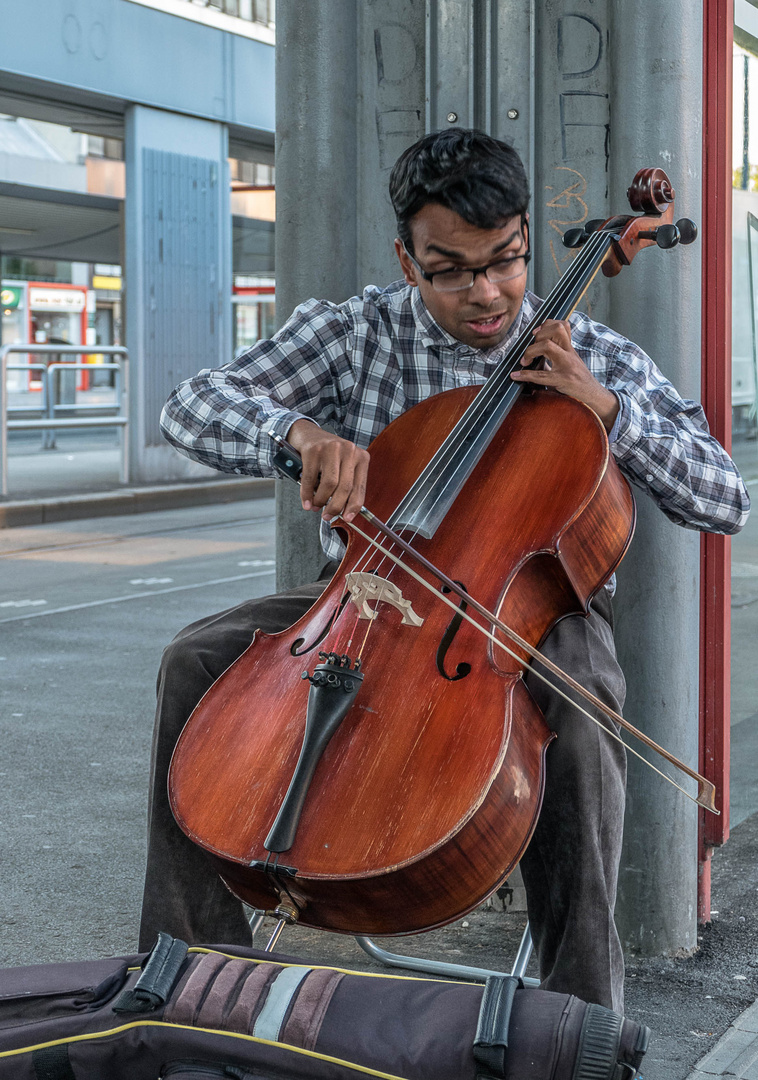 Cellist am Franz-Jonas-Platz, einem stark frequentierten Verkehrsknoten in Wien Floridsdorf.