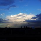 Cielo azul con un pequeño arco iris al fondo