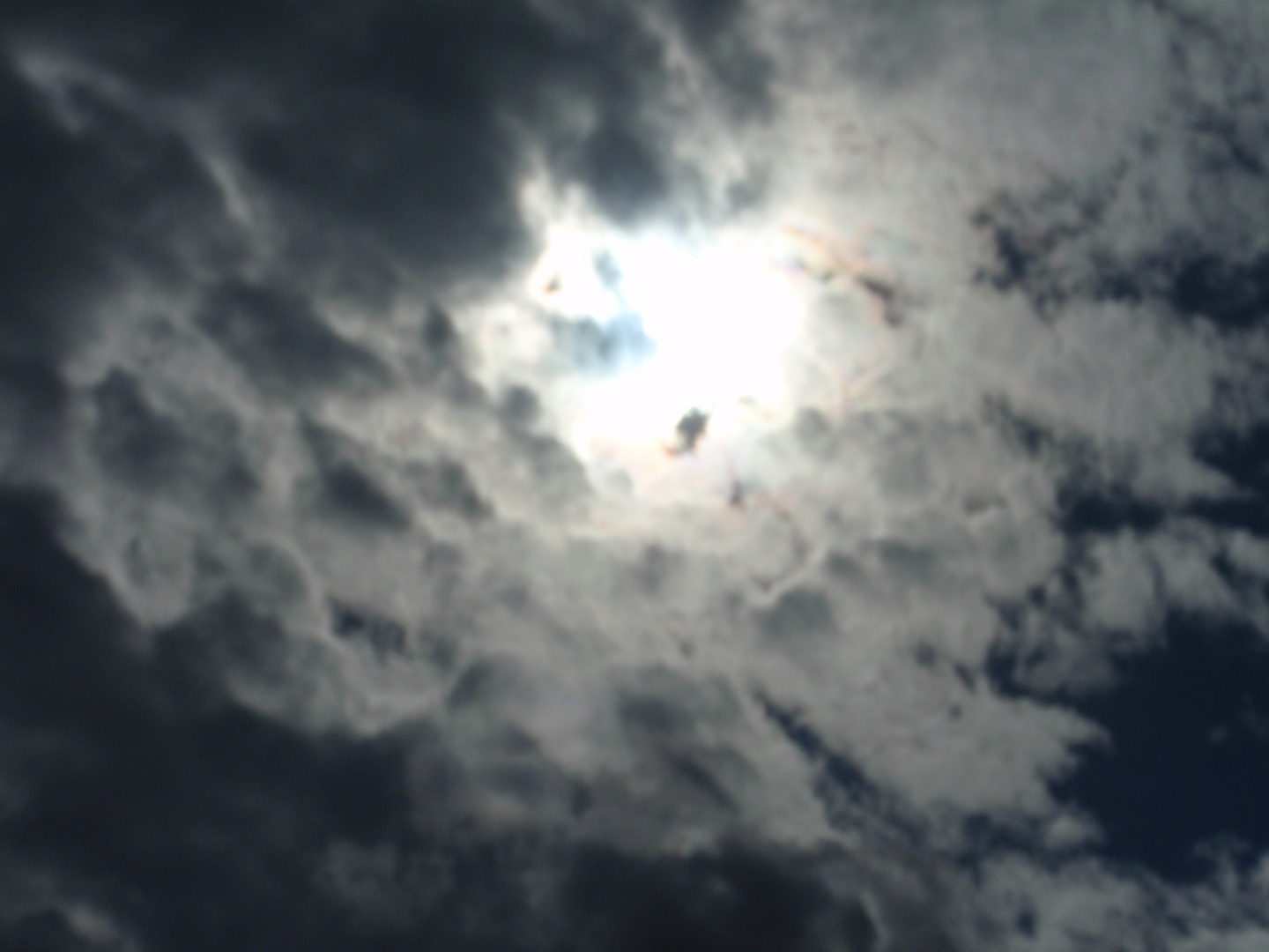 cielo con nubes oscuras a las cinco de la tarde con el sol transpasando un pequeño agujero