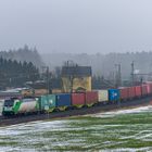 Container, Schnee und grüne Wiese