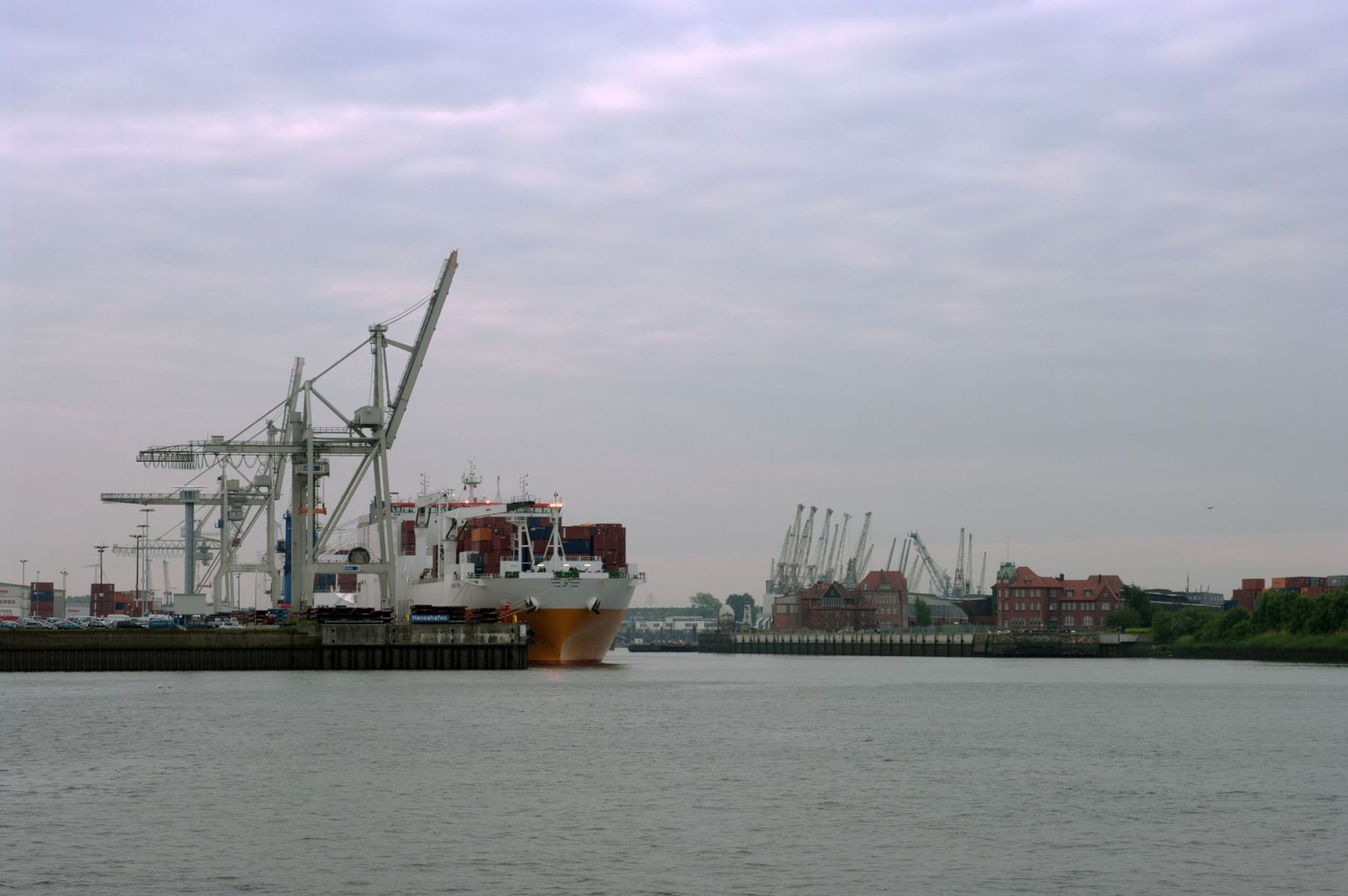 Containerriesen im Hansahafen und historische Lagerschuppen im Hafen Hamburgs