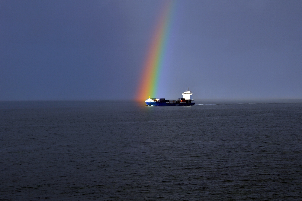 Containerschiff mit Regenbogen