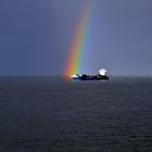 Containerschiff mit Regenbogen