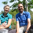 Couple of happy hikers having a picnic in a fruit orchard in the Odenwald hills