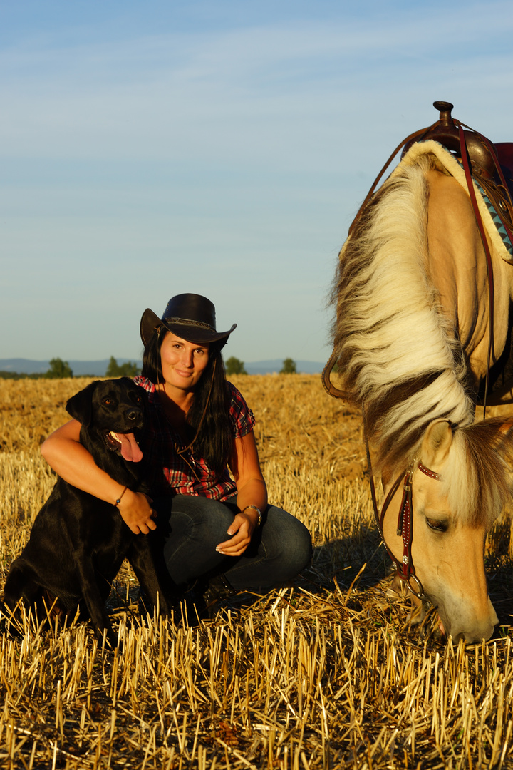 Cowgirl mit Hund und Pferd