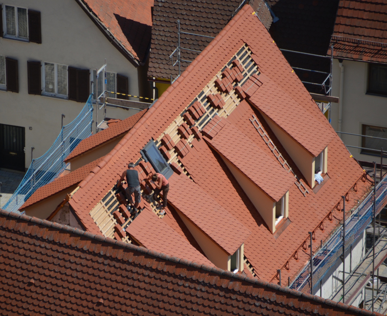 Dachdeckerin und Dachdecker von oben betrachtet 