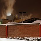 Dampf über Schnee hinter einer Mauer